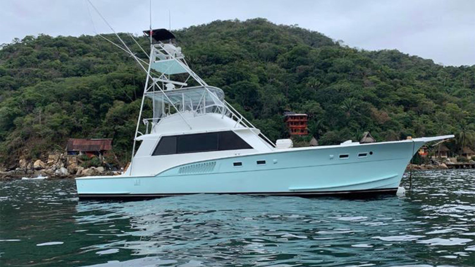 The 54 ft Hatteras sportfishing yacht with tuna tower running along the Nuevo Vallarta coast toward the offshore grounds