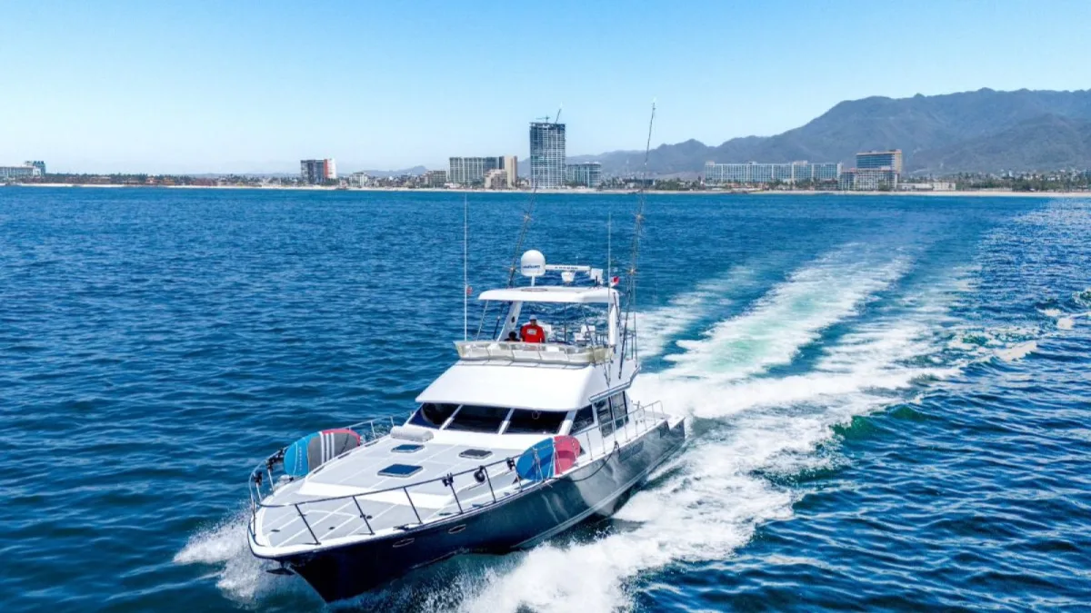 The 60 ft Mikelson sportfishing yacht leaving Marina Vallarta with the city behind